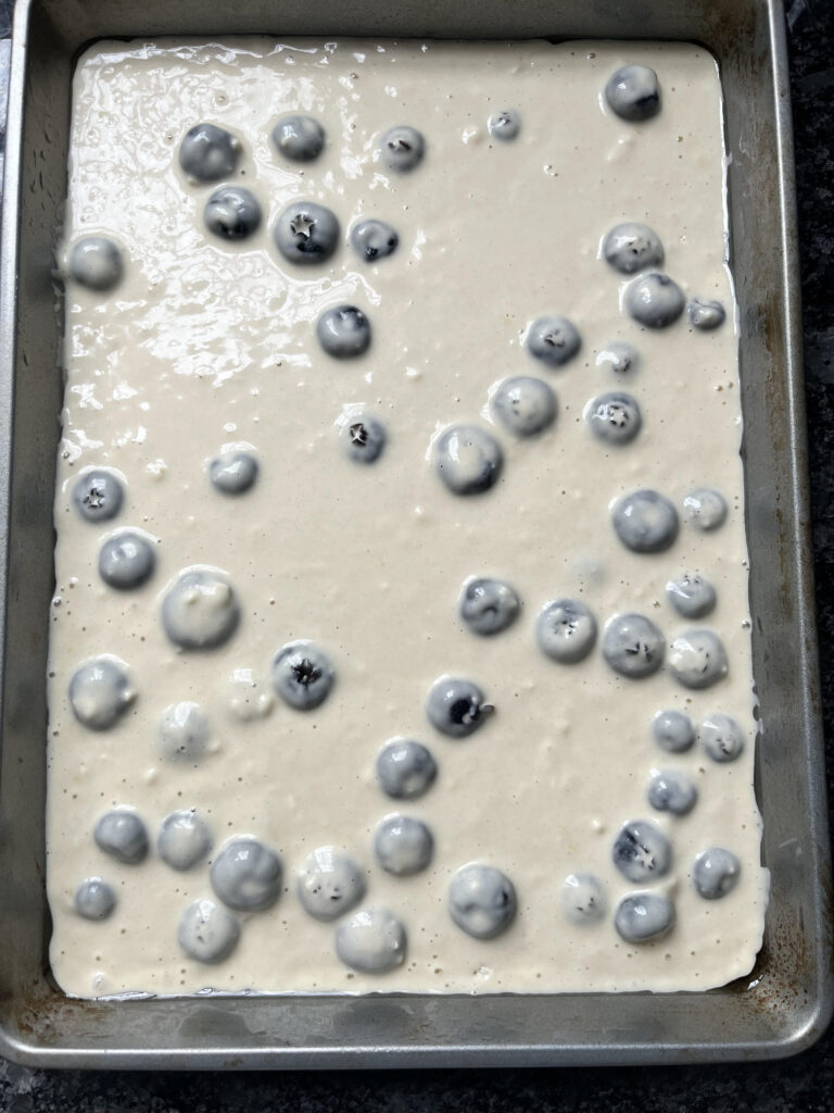 Blueberry sheet pan pancakes, unbaked, in the sheet pan.