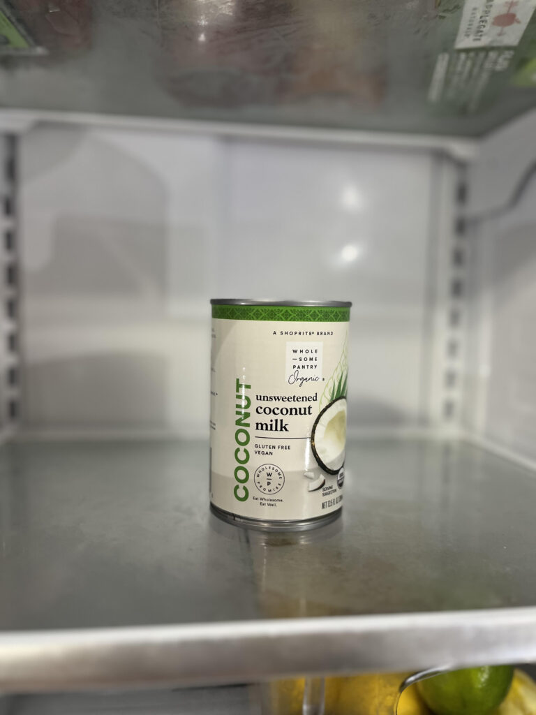 Can of organic coconut milk on an unclutered refrigerator shelf